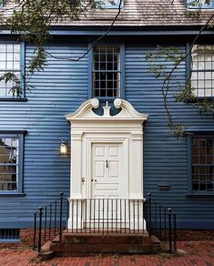 Dark blue colonial house with white door trim after painting